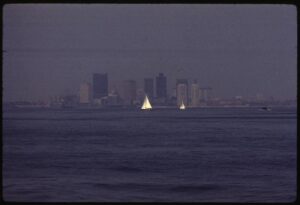 A city skyline is partly obscured by thick haze caused by air pollution.