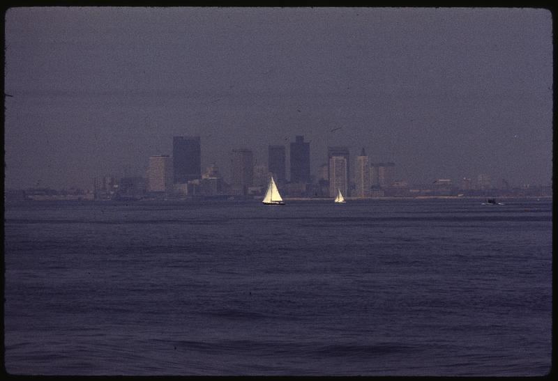 A city skyline is partly obscured by thick haze caused by air pollution.