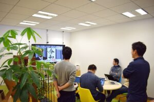 Office workers use laptops at shared desks during a collaborative working day.